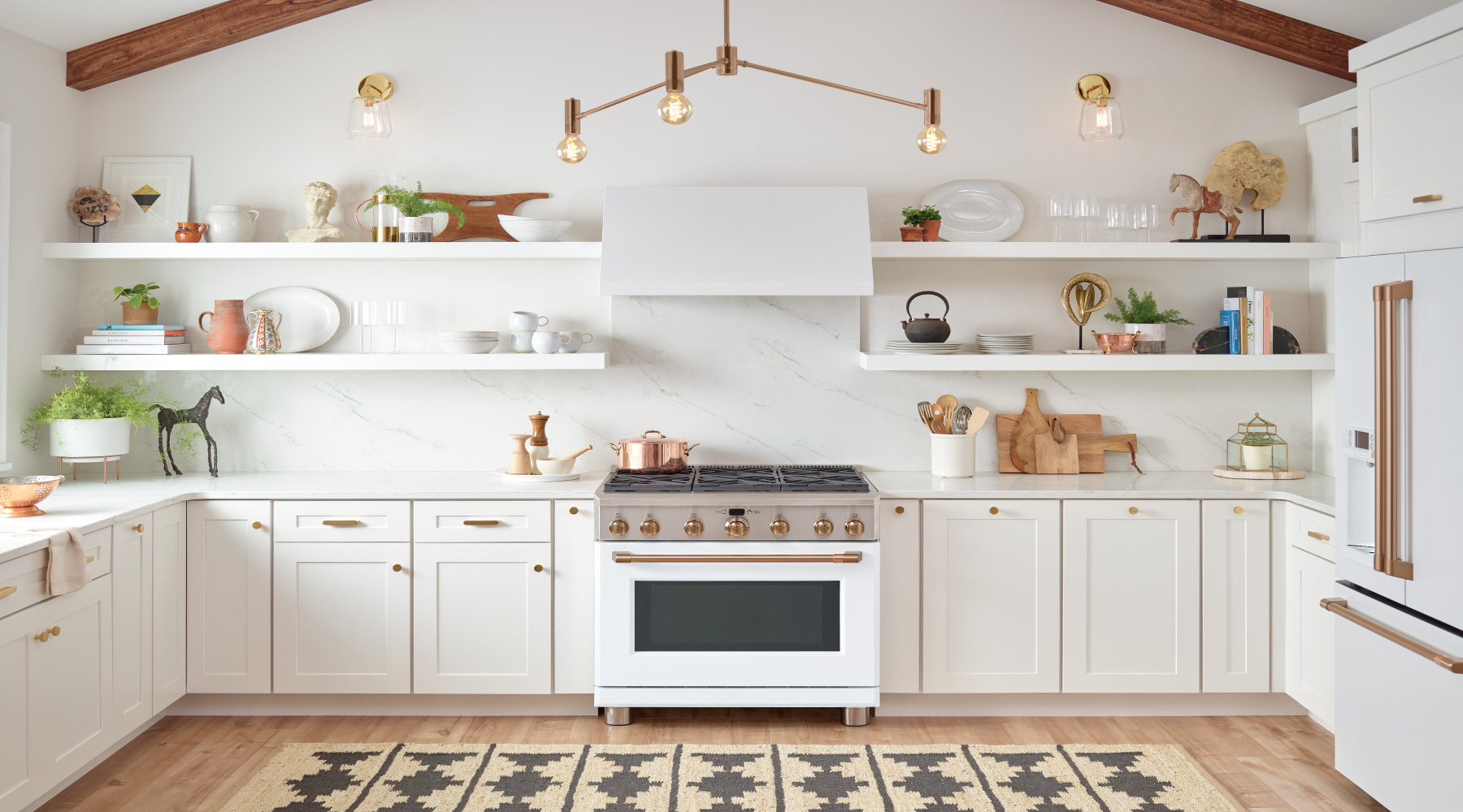 Bright kitchen with white cabinents and appliances and brass accents